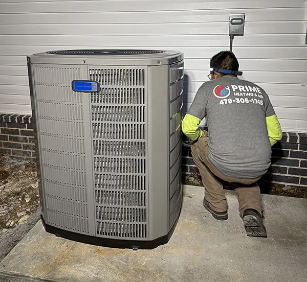 A technician from Prime Heating & Air works on a customer's air conditioning repair.